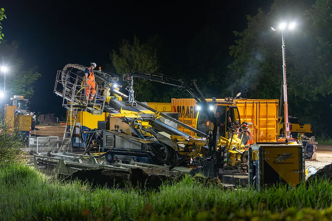 Nachtelijke werkzaamheden aan een gestuurde boring op een bouwlocatie.