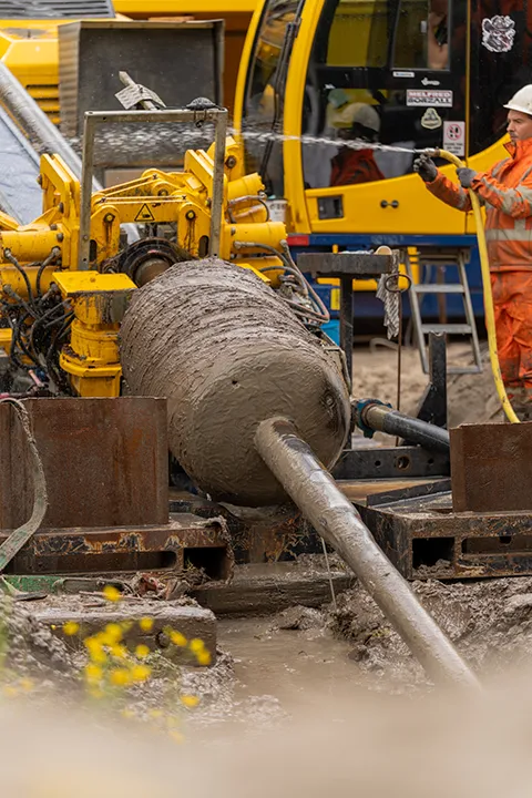 Medewerker reinigt de boorinstallatie tijdens een infrastructuurproject.