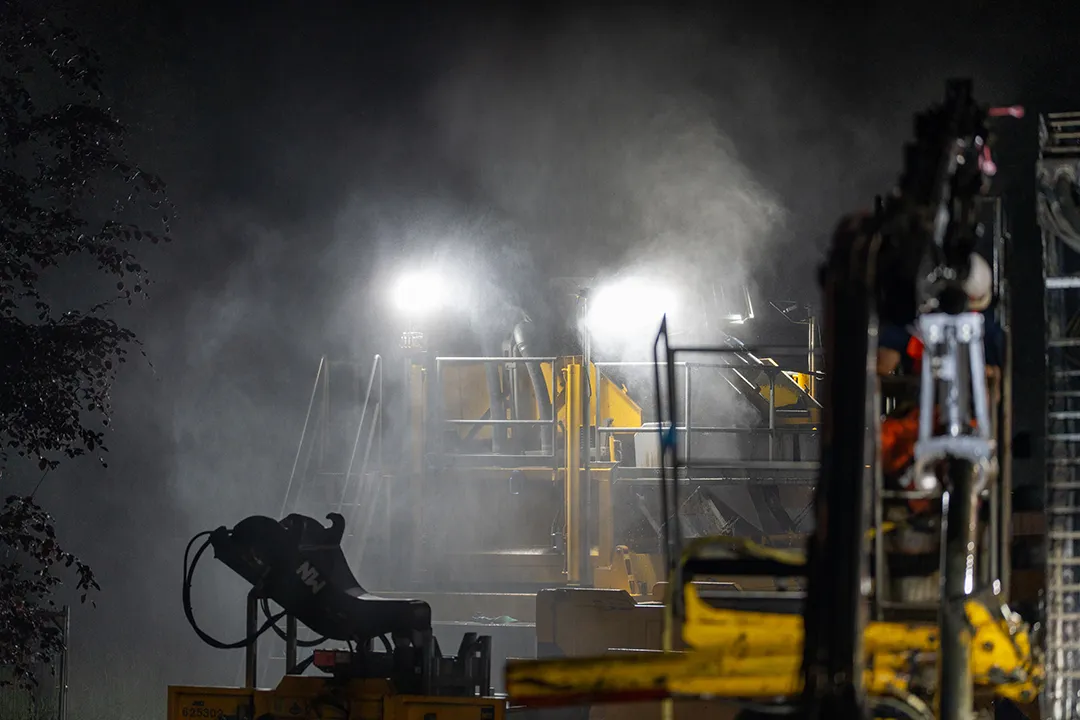 Verlichte boorinstallatie tijdens nachtelijke infrastructuurwerkzaamheden.
