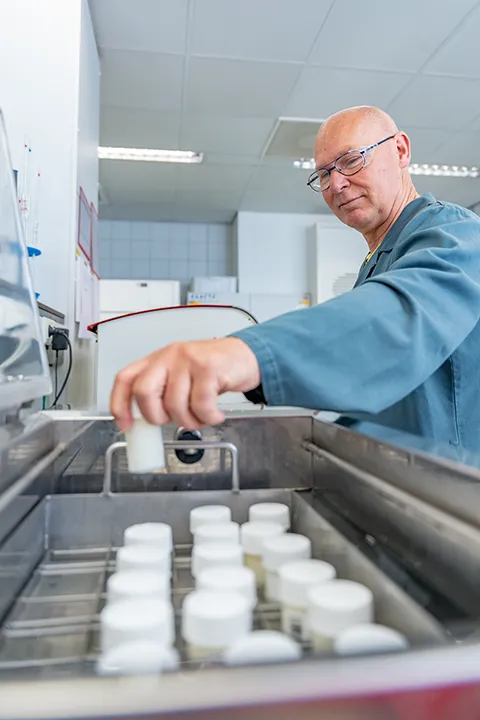 Laboratoriummedewerker pipetteert een monster tijdens kwaliteitscontrole.