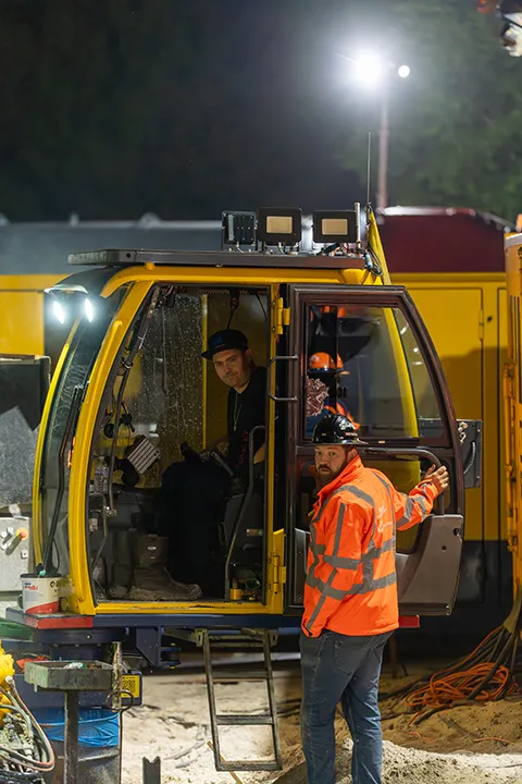 Medewerkers bij een boorinstallatie tijdens een bedrijfsreportage in de avond.