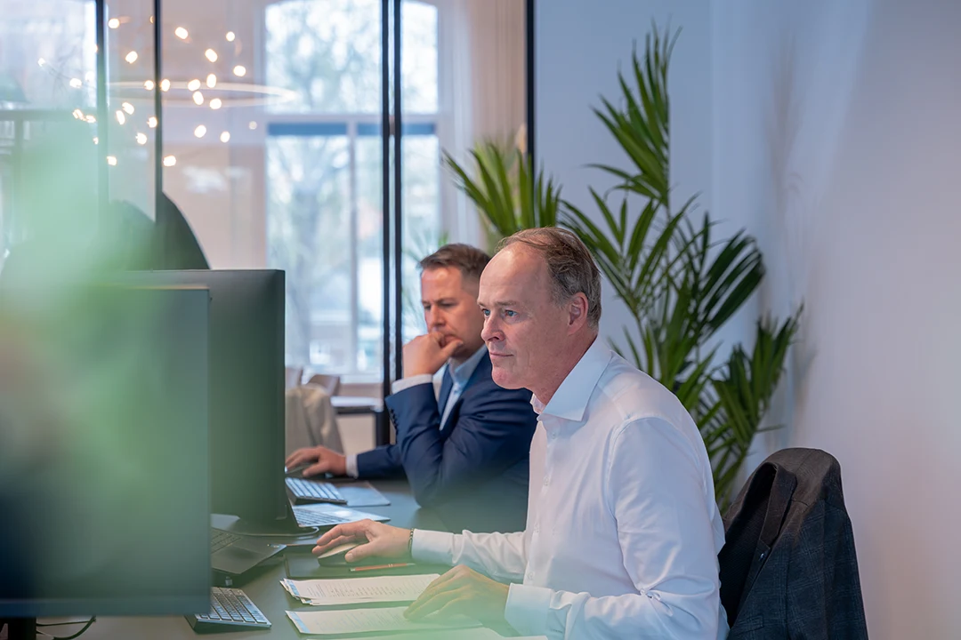 Medewerkers aan het werk achter hun computer tijdens een bedrijfsreportage