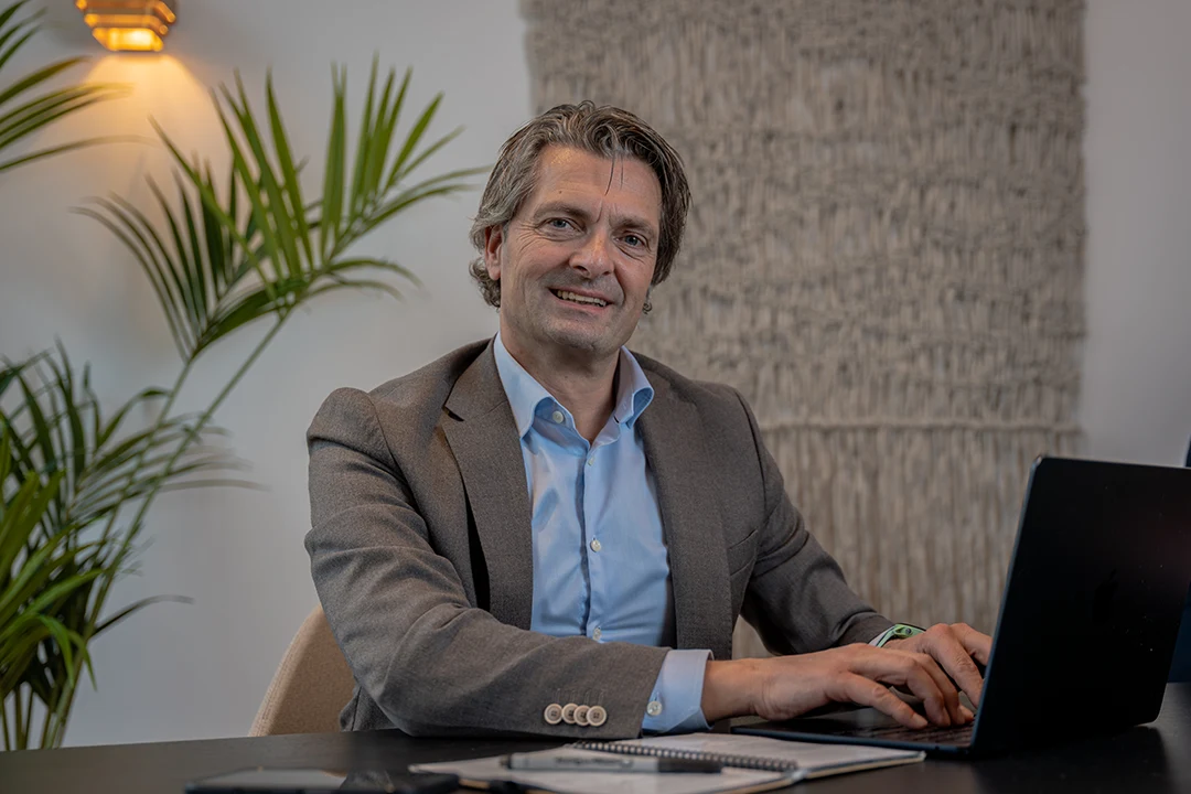 Professioneel zakelijk portret van een ondernemer achter zijn laptop
